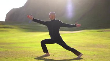 İzlanda 'da gün batımında doğada yoga yapan adam.