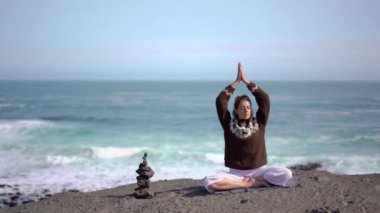 Kız okyanus ve İzlanda 'da dalgalar arasında meditasyon yapıyor.
