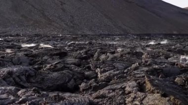 Hâlâ aktif olan bir volkanın ve İzlanda 'daki katı lav manzarasının görüntüsü.