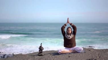 Kız okyanus ve İzlanda 'da dalgalar arasında meditasyon yapıyor.
