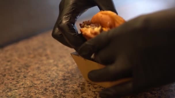 Şef Siyah Arka Planda Servis Tabağında Lezzetli Bir Burger Yapıyor — Stok video