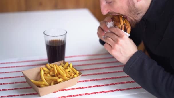 Hombre Comiendo Hamburguesa Restaurante Disfrutando Deliciosa Hamburguesa Jugosa Papas Fritas — Vídeo de stock
