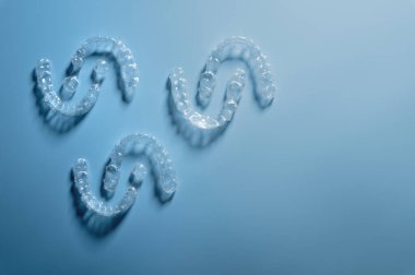 invisible plastic straighteners lie in a pattern opposite each other, space for text for a dental clinic.