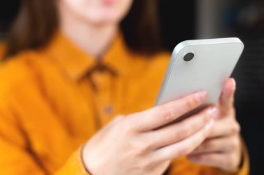 index finger of a young woman on the screen of a mobile phone. hipster girl sends a text message, touching the smartphone close-up, online internet.