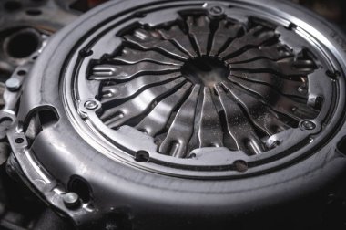 Automotive clutch mechanism, disc, basket and bearing for auto on a black background. Automotive parts. Close-up.