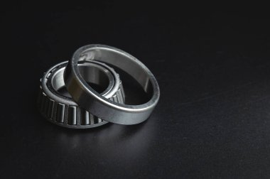 new two-piece roller bearing on a black background. Metal spare part for car suspension.