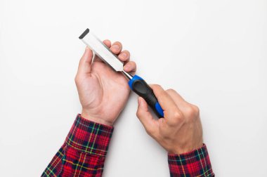 Hand tool chisel on a white background in a mans hand, top view. Craftsman in a plaid shirt holds a carpentry hand cutting tool.