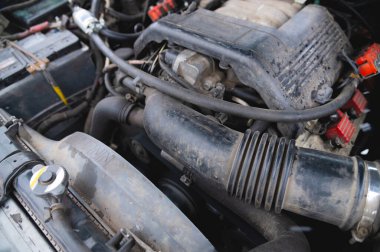 View under the hood of the car. Close-up of a V-shaped six-cylinder old engine. Dirty engine. Time for car maintenance.