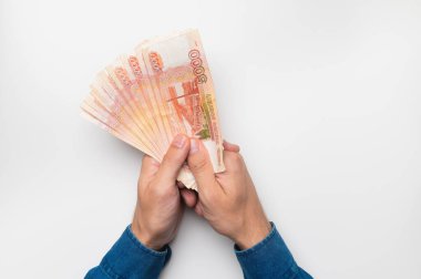 Beyaz bir arka planda Rus parası tutan bir adam. Rus rublesi, para birimi, banknotlar.