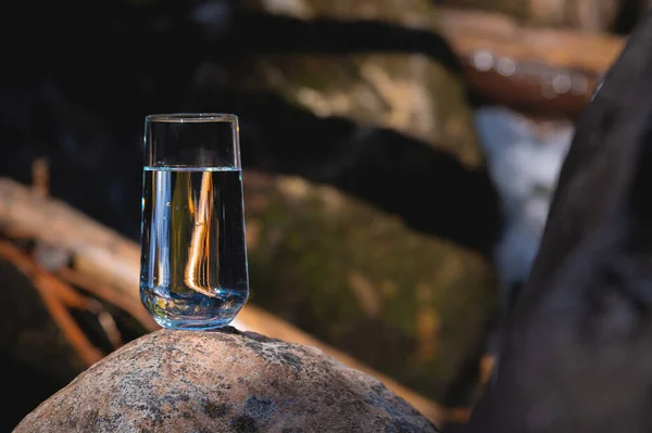 Bicchiere Acqua Sulle Pietre Fiume Sullo Sfondo Natura Sfocatura Sfondo — Foto Stock