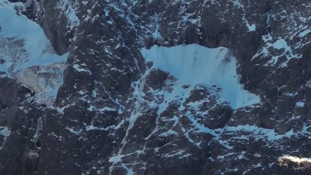 Telephoto镜头的特写是一个陡峭的岩石部分地撒满了雪的特写 极端登山的地点 航拍视图 — 图库视频影像