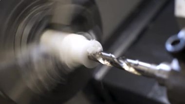 Caprolon 'dan bir parça yapmak için otomatik torna tezgahına yakın çekim. Mühendislik fabrikasının endüstriyel görüntüleri..