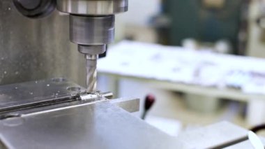 Fabrikadaki üretim makinelerinin işi. CNC değirmen makinesinde metal plakaları öğütme sürecinin etrafında dön. Değirmen makinesinde değirmen dükkanı.