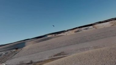 Boş sonbahar tarlaları üzerinde İHA kanat fpv uçuşu. Uzaktan kumandalı bir uçağı takip eden bir İHA yüksek hızda hareket ediyor..