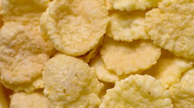 Mısır gevreği müsli dokusu yakın çekim hareketi, yulaf ezmesi kuru müsli, sabah kahvaltısı için mısır gevreği pişirme. Dönen arkaplan.