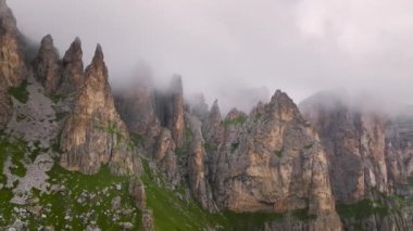 Güneşli bir günde parçalı bulutlu dağların kayalık zirvesinin havadan görünüşü. Dağlarda hava değişiyor..