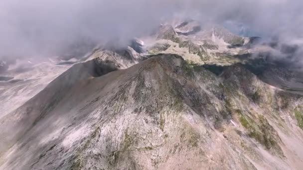 电影的空中无人机图像未知的岩石山在高山的山脊在高加索 阳光灿烂的日子 四周环绕着高山湖泊和悬崖峭壁 周围的云彩形成 — 图库视频影像
