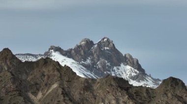 İnsansız hava aracından teleskoba, çok boyutlu dağlara, kayalara ve bayırlara hava görüntüsü. Dağlarda karla kaplı dağ tepeleri.