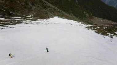 İki kayakçı çimlerin arasındaki geçitte yüksek hızda at sürerler. hava görünümü.