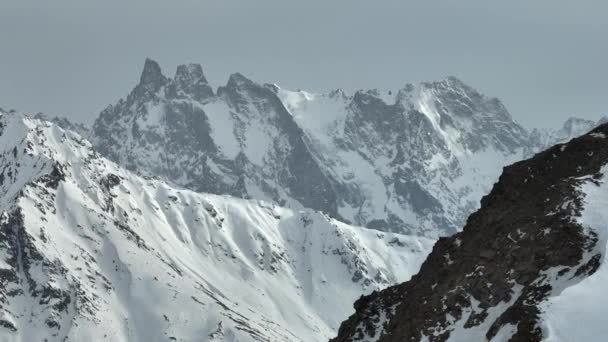 ドローンからの空中ビュー望遠レンズ多次元の山の岩や尾根 山の中の雪に覆われた山の峰岩 — ストック動画