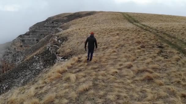 Vista Aérea Homem Caminhando Longo Borda Planalto Frente Penhasco Nevoeiro — Vídeo de Stock