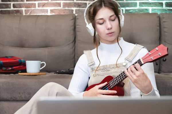 Kaukaska Dziewczyna Słucha Muzyki Przez Słuchawki Przygotowuje Się Gry Gitarze — Zdjęcie stockowe