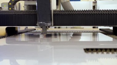 Otomatik bir CNC makinesinin endüstriyel videosu. Metal levhaları işleyen lazer kesme makinesi. Lazer kesme ekipmanları metalde kesintiler yapıyor.
