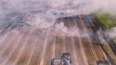 Yanan ve dumanı tüten bir alanda uçan hava aracı. Hava kirliliği krizi iklim değişikliği. Kuru havalarda kurak çimenler yanar. Hava kirliliğinin çevresel sorunu. Hava görünümü