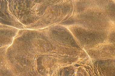 Şeffaf berrak deniz, yakın plan. Geçmişi. Deniz kumlu tabanı. Suyun üzerindeki en üst manzara.