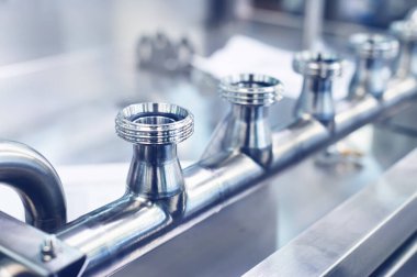 Ayırma borusu paslanmaz çelikten ve dirsekleri dişli bir şekilde üretilmiş. Üretim hatları için metal yapılar. Tonu ayarlanmış resim.