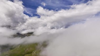 Geriye doğru hareket. Güneşli bir günde bulutlardaki hareketliliğin havadaki hızlandırılmış görüntüsü. Kalın bulutlarda video arkaplan uçuşu.