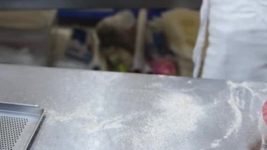 Dişi eller hamuru küçük bir fırında zanaatkar ev yapımı ekmek yapmak için parçalara ayırıyor..