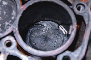 Bozuk bir motorun silindir bloğunda karbon birikintileri olan içten yanmalı motorun hasarlı pistonuna yakın çekim. Pistondan kopan metal parçaları.