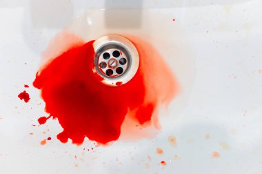 Su ve kan damlaları beyaz bir lavaboya akıyor. Yakın çekim kan gölü, banyoda kaza..