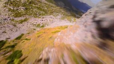 Dik kayalık yamaçlardan aşağı hızlı dalış güneşli bir günde resimli kaya kanyonu, Fpv yarış aracı, ilk hava manzaralı bakış açısı.