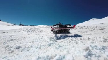 Kar temizleme makinesi olan kırmızı, modern bir kar aracı bir kayak merkezinde bir kayak pisti hazırlıyor. Ağır ekipman ve maden ekipmanları için takip edilen araç.