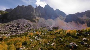Dağ vadisini ilk gören kişi. Dağların ve gökyüzünün insansız hava aracı görüntüsü, aşağıdaki ağaçların yeşilliğini gösteren yumuşak bir uçuş..
