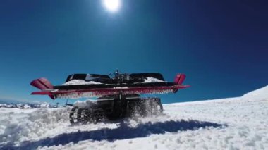 Kar temizleme makineli bir kar aracıyla karlı bir pistte kayak yapmaya hazırlanan bir kar aracının yakın görüntüsü. Ağır makineler, yavaş hareket eden kar kaldırma.