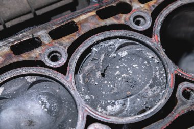 Bozuk bir motorun silindir bloğunda karbon birikintileri olan içten yanmalı motorun hasarlı pistonuna yakın çekim. Pistondan kopan metal parçaları.