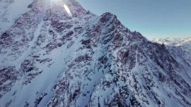 Hava manzarası, dağın tepesine uçmak, kaya dokusu, alp güneşli manzara. Birinci şahıs görüşlü spor dronu, destansı kaya manzarası, vahşi tepe vadisi, donmuş buzullar..