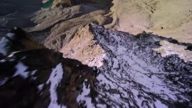Kayalık bir dağın tepesinden kayaların altına atla. Kayalık dağ yamacında uçan FPV uçağı. Uçurumdan düşüşün nefes kesici görüntüleri..