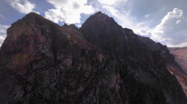 Hızlı aşırı yakın çekim dik kayalık dağ yamaçlarına tırmanma ve güneşli bir günde dar dolambaçlı akıntısı olan pitoresk kaya kanyonu, Fpv yarış dronu, hava sinemasının ilk noktası