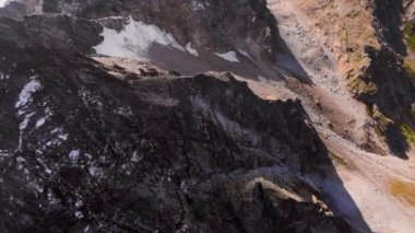 Hızlı aşırı yakın plan dalış dik kayalık dağ yamaçlarında ve manzaralı kaya kanyonunda güneşli bir günde dar bir akıntı, Fpv yarış dronu, hava sinemasının ilk noktası