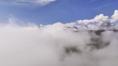 Geriye doğru hareket. Güneşli bir günde bulutlardaki hareketliliğin havadaki hızlandırılmış görüntüsü. Kalın bulutlarda video arkaplan uçuşu.
