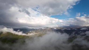 Dağlarda gökkuşağı, yağmurda gökkuşağı, dağ manzarasında gökkuşağı, dağlarda gökkuşağı ve yağmurdan sonra dramatik dağ bulutları..