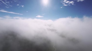Gün batımında bulutların üzerinde alçak uçuş. Hava manzaralı. Uçak birinci şahıs görüntüsü.