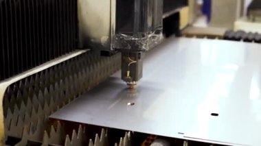 Otomatik bir CNC makinesinin endüstriyel videosu. Metal levhaları işleyen lazer kesme makinesi. Lazer kesme ekipmanları metalde kesintiler yapıyor.