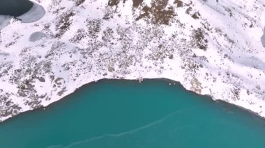 Kışın Sofya göllerinin havadan görünüşü. Karla kaplı kayalarla çevrili parlak turkuaz alp gölü.