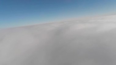 Hava manzaralı. İnsansız bir FPV planörüyle bulutların üzerinde alçaktan uçuyor. Bulut sörfü. Düşük bulutlu bir yüzeyde süzülüyor. bulut arkaplanı.