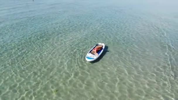 Seorang Wanita Muda Kaukasia Berbaring Paddleboard Sambil Berjemur Relaksasi Permukaan — Stok Video